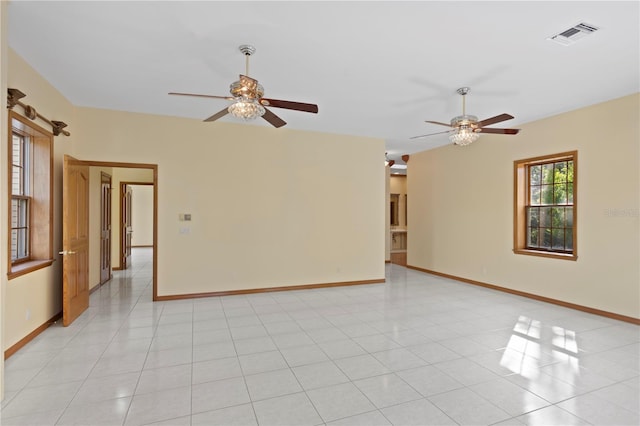 empty room with baseboards, visible vents, and ceiling fan