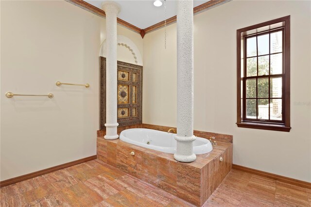 full bath with baseboards, ornate columns, ornamental molding, and a bath