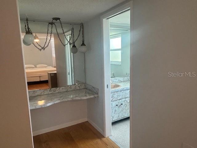 7461 W Country Club Dr N Unit 201, Sarasota, FL 34243 - interior space with a chandelier, wood finished floors, a textured ceiling, and baseboards