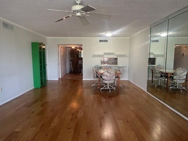 7461 W Country Club Dr N Unit 201, Sarasota, FL 34243 - dining room featuring a ceiling fan, wood finished floors, ornamental molding, a textured ceiling, and baseboards