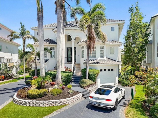 7118 Hawks Harbor Cir, Bradenton, FL 34207 - mediterranean / spanish-style home with stucco siding, an attached garage, a tile roof, and aphalt driveway