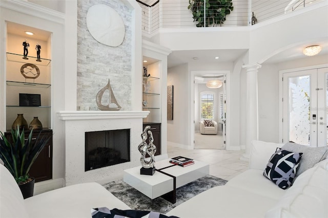 7118 Hawks Harbor Cir, Bradenton, FL 34207 - living area with french doors, a towering ceiling, arched walkways, built in shelves, and ornate columns