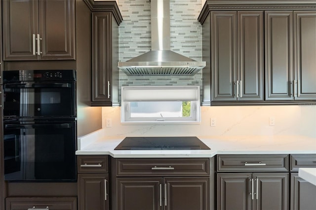 7118 Hawks Harbor Cir, Bradenton, FL 34207 - kitchen with dark brown cabinetry, tasteful backsplash, light stone counters, black appliances, and wall chimney exhaust hood