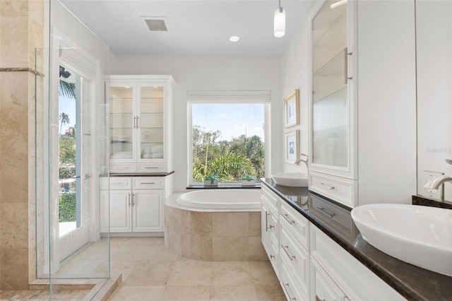 7118 Hawks Harbor Cir, Bradenton, FL 34207 - bathroom featuring a garden tub, a sink, double vanity, and tiled shower