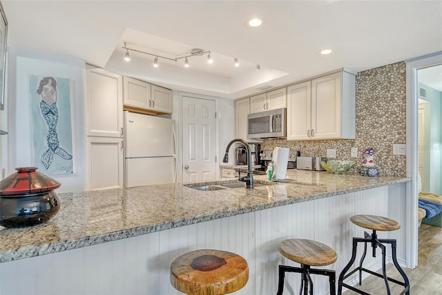 5920 Midnight Pass Rd Unit 406, Sarasota, FL 34242 - kitchen featuring stainless steel appliances, a sink, light stone countertops, a peninsula, and tasteful backsplash