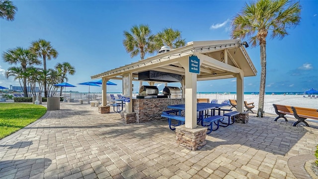 5920 Midnight Pass Rd Unit 406, Sarasota, FL 34242 - view of patio featuring an outdoor kitchen, a gazebo, view of water and beach, and outdoor dining area