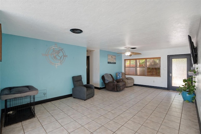 interior space with ceiling fan, baseboards, and a textured ceiling