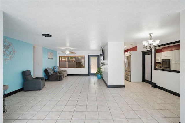 unfurnished living room featuring baseboards, light tile patterned flooring, and ceiling fan with notable chandelier