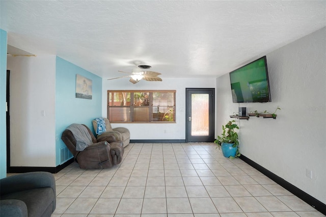 living room with a ceiling fan, baseboards, and light tile patterned floors