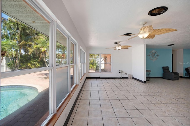 unfurnished sunroom with baseboards and tile patterned flooring