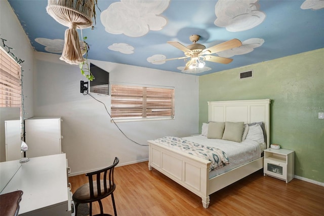 bedroom featuring wood finished floors, visible vents, baseboards, and ceiling fan