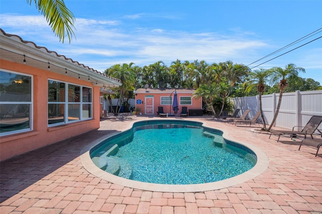 view of pool with a fenced backyard, an outdoor structure, a patio area, and a fenced in pool