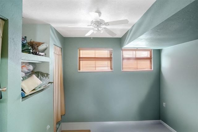 spare room with a ceiling fan and a textured ceiling