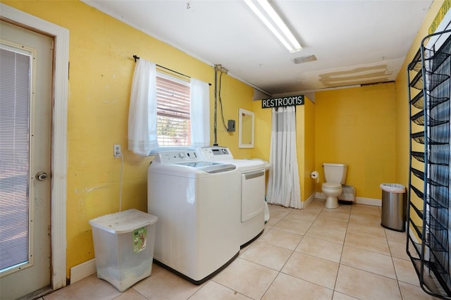 laundry room featuring washer and clothes dryer, laundry area, and light tile patterned floors