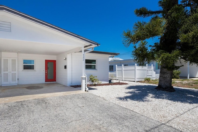 view of front of property featuring concrete block siding and fence