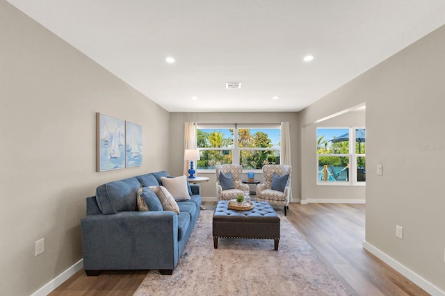 living room featuring wood finished floors, baseboards, visible vents, and recessed lighting