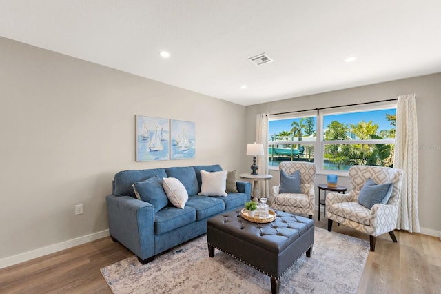 living room featuring recessed lighting, visible vents, light wood-type flooring, and baseboards