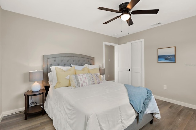 bedroom with visible vents, baseboards, a ceiling fan, and wood finished floors