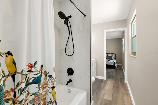 bathroom with toilet, wood finished floors, shower / bath combo with shower curtain, and baseboards