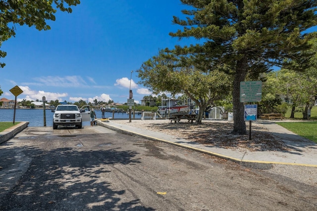 view of road with a water view, curbs, and sidewalks