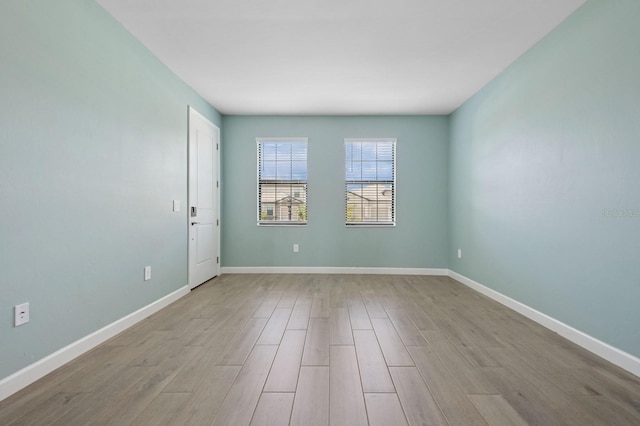 empty room featuring baseboards and wood finished floors