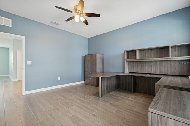 unfurnished office with light wood finished floors, baseboards, a ceiling fan, and visible vents