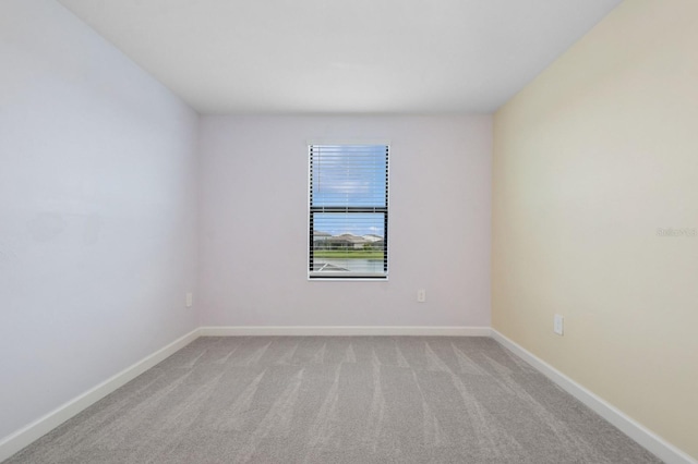 empty room with baseboards and light colored carpet