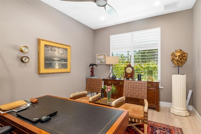 office area featuring baseboards, a ceiling fan, visible vents, and light wood-type flooring