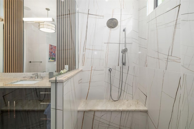 full bathroom with a tile shower and vanity