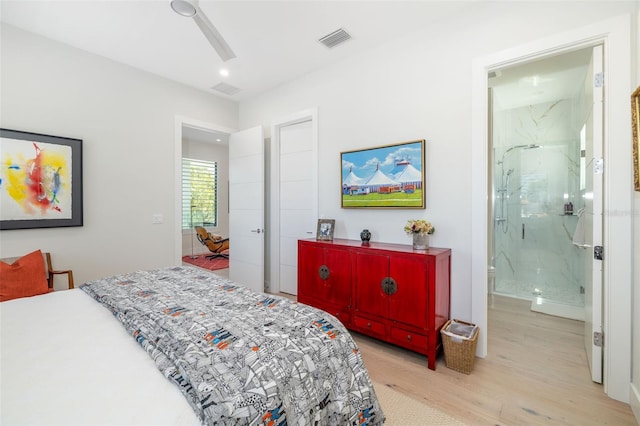 bedroom with ensuite bath, light wood-style flooring, visible vents, and a ceiling fan