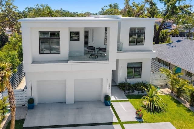 view of front facade featuring an attached garage, driveway, fence, and stucco siding