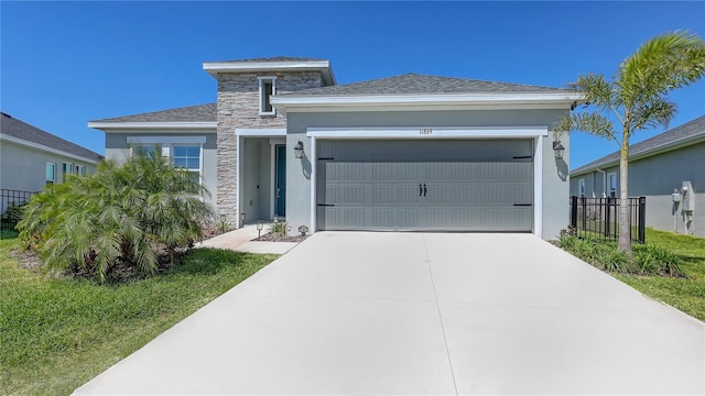 view of front of property featuring stucco siding, an attached garage, driveway, and stone siding