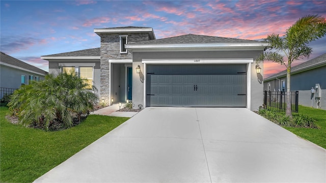 view of front of house with a garage, stucco siding, and stone siding