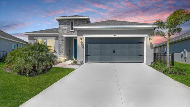 11869 Richmond Trl, Parrish, FL 34219 - view of front of house with a garage, stucco siding, and stone siding