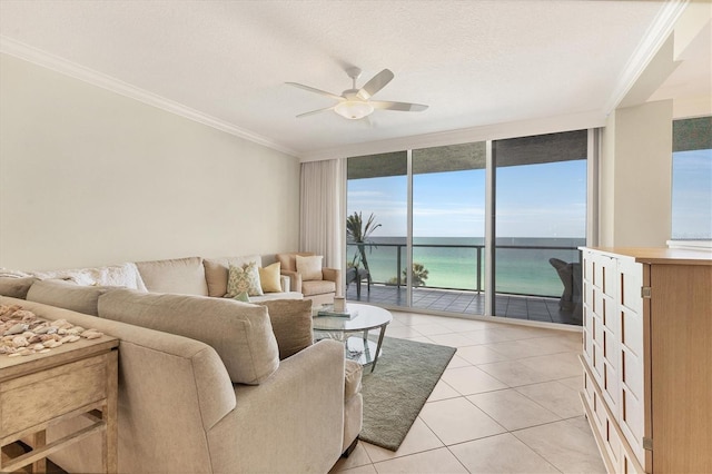 living area with crown molding, ceiling fan, light tile patterned floors, a water view, and expansive windows
