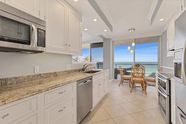 kitchen featuring a sink, appliances with stainless steel finishes, light stone countertops, and white cabinetry