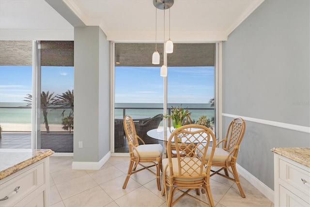 dining space featuring a wall of windows, light tile patterned floors, baseboards, a water view, and ornamental molding