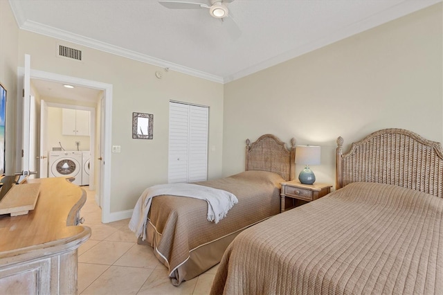 bedroom featuring independent washer and dryer, visible vents, a closet, ornamental molding, and light tile patterned flooring
