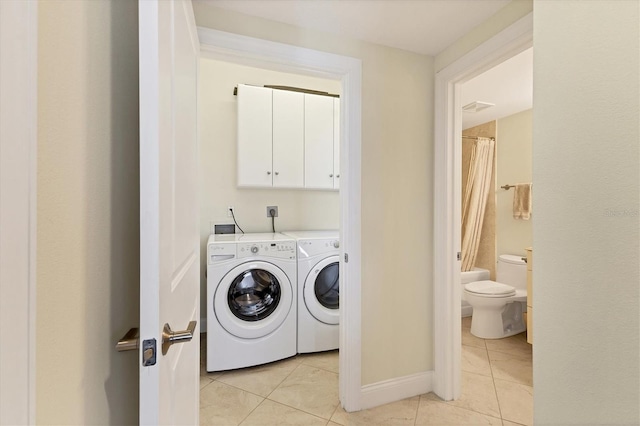 washroom featuring visible vents, cabinet space, light tile patterned floors, baseboards, and washer and clothes dryer