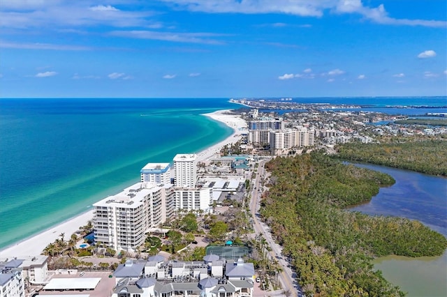 drone / aerial view featuring a water view, a view of the beach, and a view of city