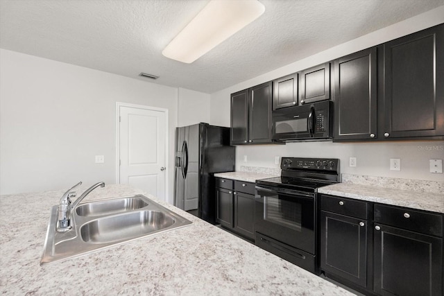 14914 Flowing Gold Dr, Bradenton, FL 34212 - kitchen with black appliances, dark cabinets, a sink, light countertops, and a textured ceiling