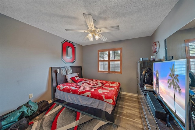 4053 Lancaster Dr, Sarasota, FL 34241 - bedroom featuring wood finished floors, a textured ceiling, a ceiling fan, and baseboards