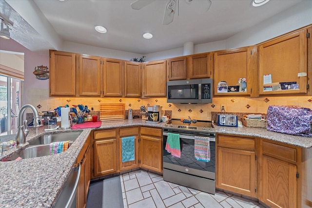 4053 Lancaster Dr, Sarasota, FL 34241 - kitchen featuring light stone counters, decorative backsplash, stainless steel appliances, and a sink