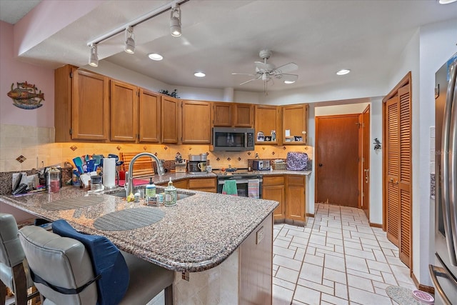 4053 Lancaster Dr, Sarasota, FL 34241 - kitchen with a ceiling fan, a sink, stainless steel electric range oven, track lighting, and a peninsula