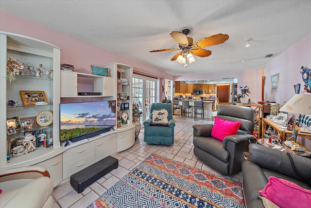 4053 Lancaster Dr, Sarasota, FL 34241 - living room with a ceiling fan, visible vents, a textured ceiling, and light tile patterned floors