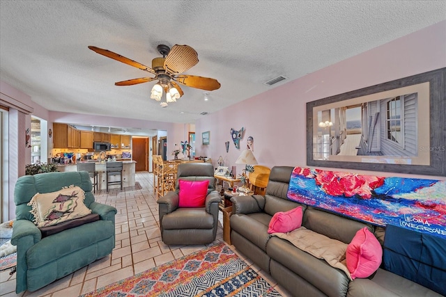 4053 Lancaster Dr, Sarasota, FL 34241 - living room featuring a ceiling fan, a textured ceiling, visible vents, and light tile patterned floors