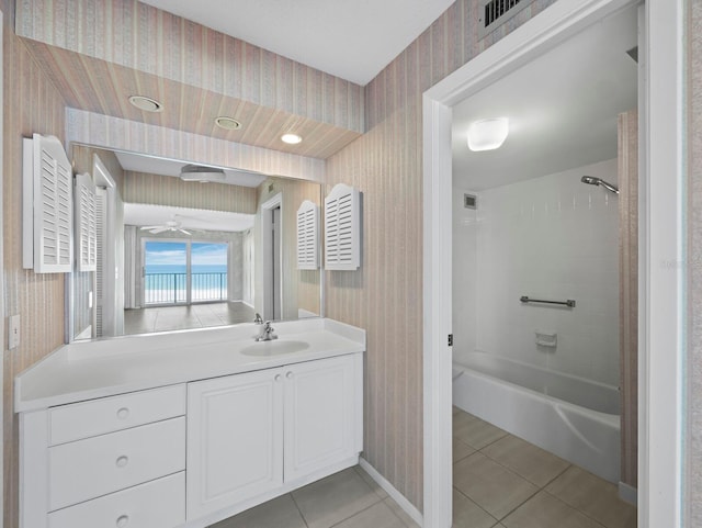 bathroom with wallpapered walls, tile patterned flooring, baseboards, ceiling fan, and shower / washtub combination