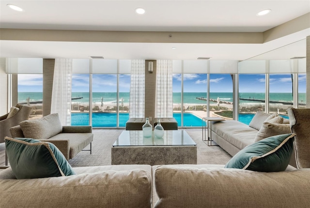 living area with a wall of windows, healthy amount of natural light, a water view, and recessed lighting