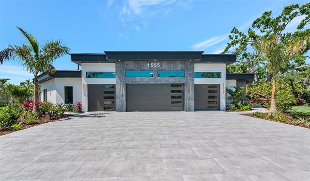 view of front of property featuring an attached garage, stucco siding, and decorative driveway