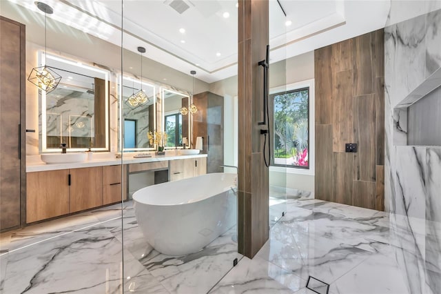 full bath featuring vanity, a freestanding tub, marble finish floor, a raised ceiling, and visible vents